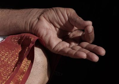 Close-up of hands in a specific yoga mudra, showing focus and detail.